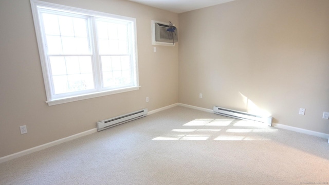 spare room featuring a wall mounted air conditioner, light colored carpet, and baseboard heating