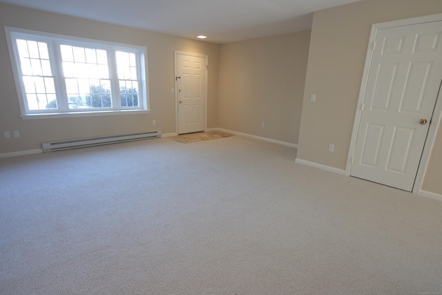 carpeted spare room featuring a baseboard heating unit