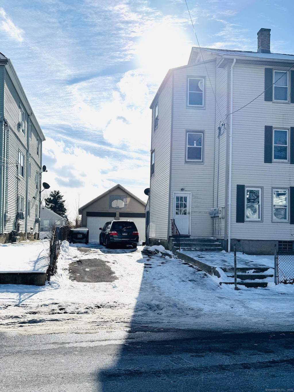 snow covered property with an outbuilding and a garage