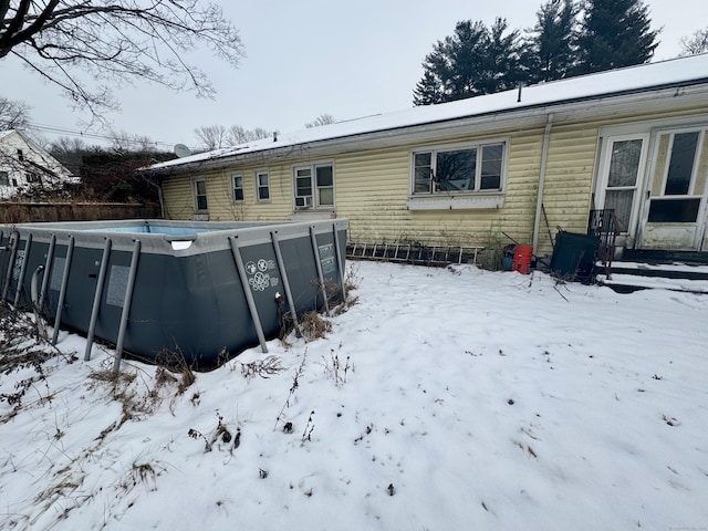 snow covered house featuring an outdoor pool