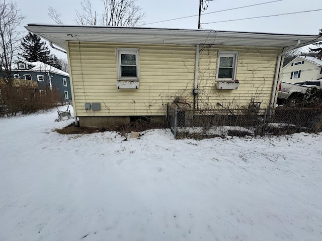 snow covered property with fence