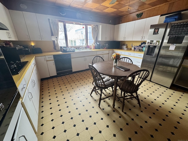 kitchen featuring light floors, light countertops, white cabinetry, dishwasher, and stainless steel fridge with ice dispenser