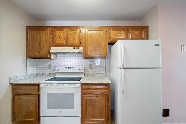 kitchen with light stone counters, white appliances, and decorative backsplash