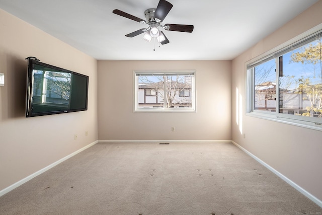 carpeted spare room featuring ceiling fan