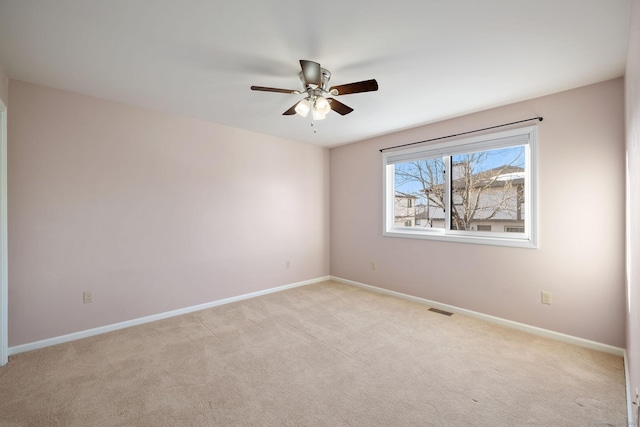 empty room featuring light colored carpet and ceiling fan