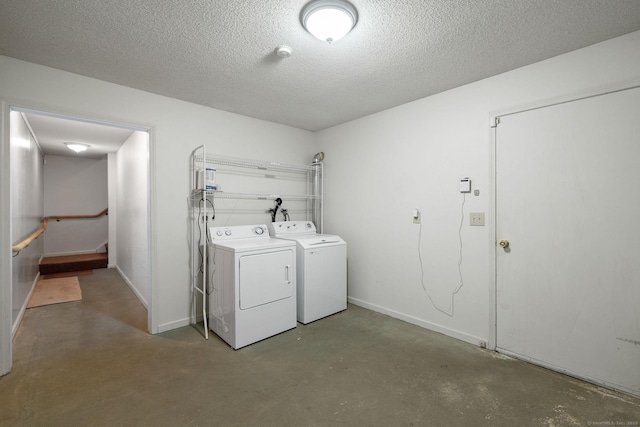 laundry room featuring separate washer and dryer and a textured ceiling