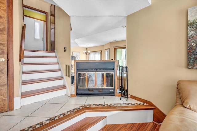 unfurnished living room with a chandelier and light tile patterned floors