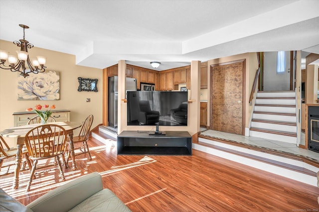 living room with a notable chandelier and light hardwood / wood-style flooring