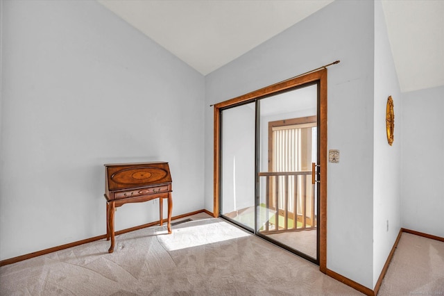 doorway featuring light carpet and lofted ceiling