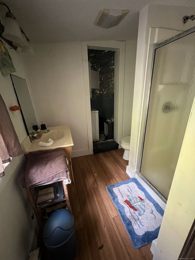 bathroom featuring an enclosed shower, hardwood / wood-style floors, vanity, and toilet