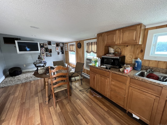 kitchen with sink, wood-type flooring, and a textured ceiling