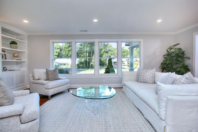 living room with hardwood / wood-style flooring, crown molding, a wealth of natural light, and built in features