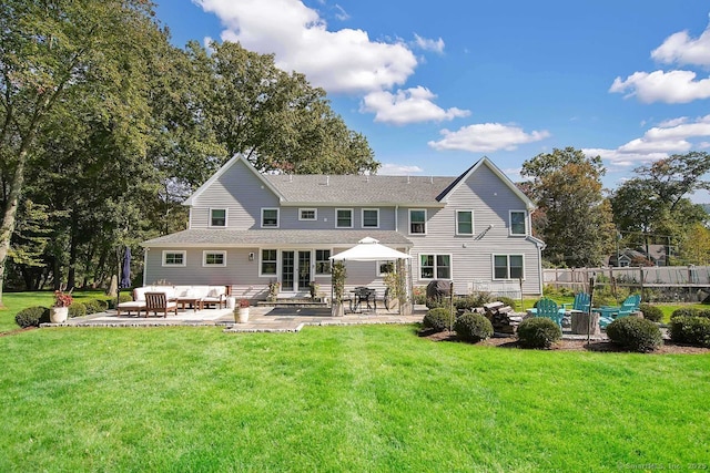 rear view of house with a patio and a lawn