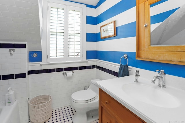 bathroom with vanity, a wealth of natural light, tile walls, and toilet