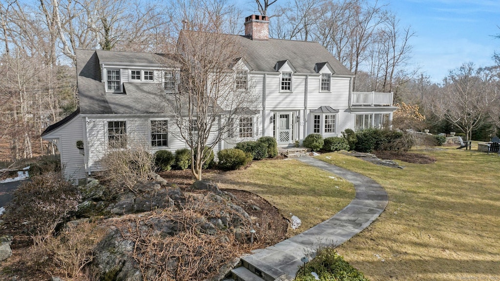 view of front of property with a balcony and a front yard