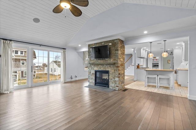 unfurnished living room featuring crown molding, light hardwood / wood-style flooring, ceiling fan, high vaulted ceiling, and a fireplace