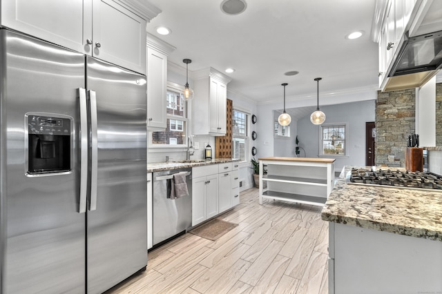 kitchen with stainless steel appliances, hanging light fixtures, and white cabinets