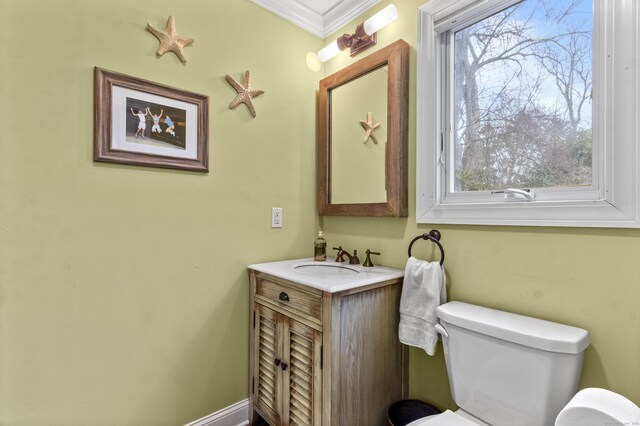 bathroom featuring ornamental molding, vanity, and toilet