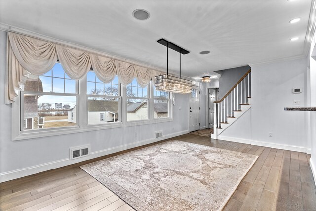 unfurnished dining area with wood-type flooring and ornamental molding