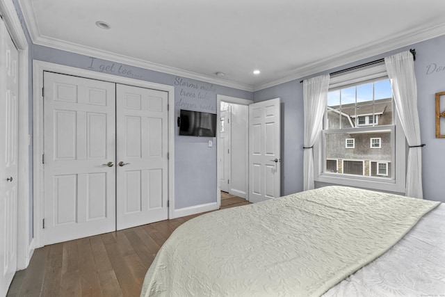 bedroom with a closet, ornamental molding, and dark hardwood / wood-style floors