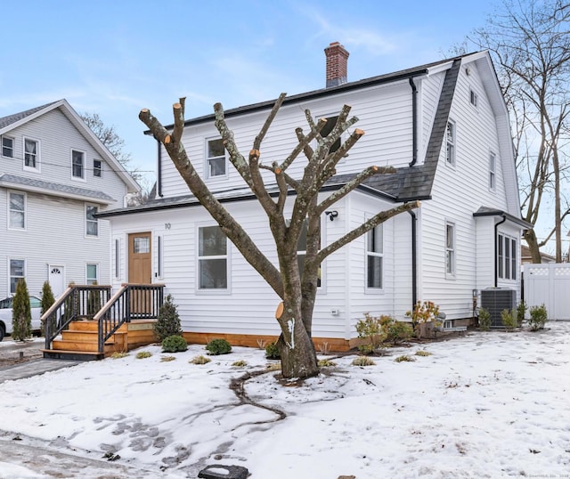 snow covered property featuring central AC