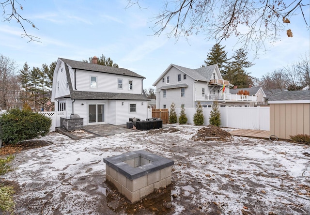 snow covered house featuring a fire pit