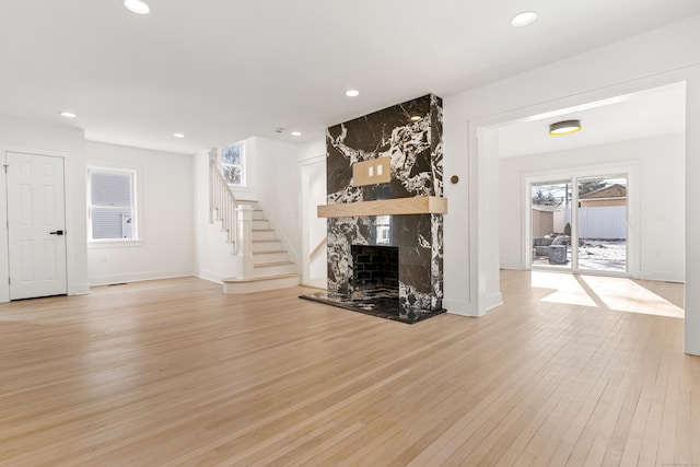 unfurnished living room with light hardwood / wood-style flooring and a high end fireplace