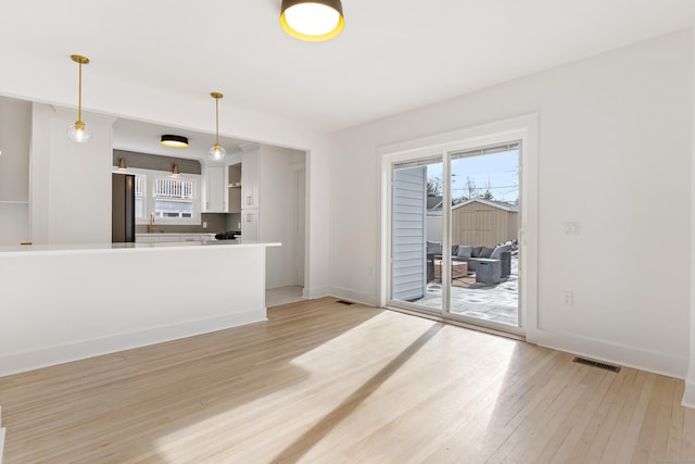 unfurnished living room with sink and light wood-type flooring