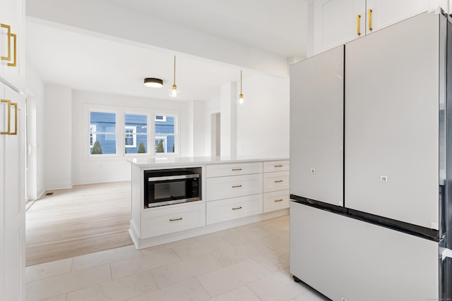 kitchen with hanging light fixtures, white cabinets, and white fridge