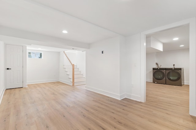 basement with light hardwood / wood-style flooring and washer and dryer