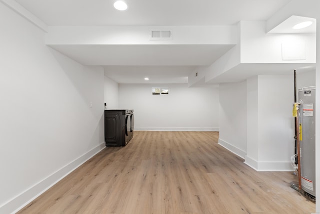 basement featuring gas water heater and light hardwood / wood-style floors