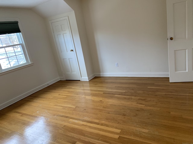 interior space featuring lofted ceiling and light hardwood / wood-style flooring