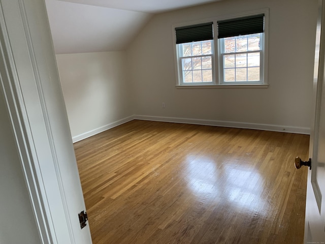 bonus room featuring lofted ceiling and light wood-type flooring