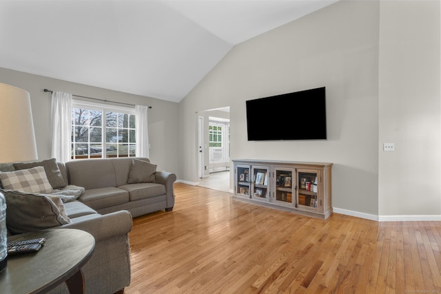 living room featuring lofted ceiling and light hardwood / wood-style floors