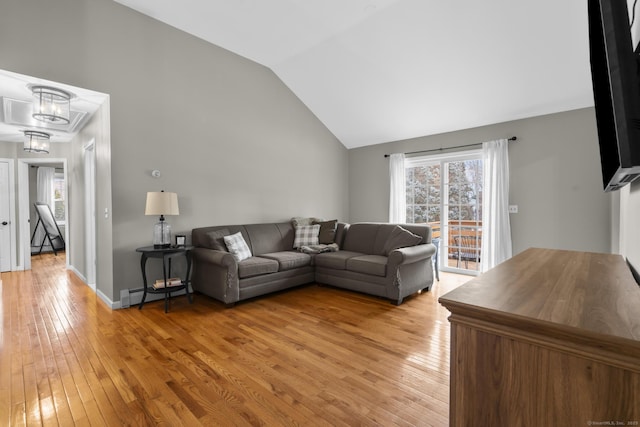 living room featuring vaulted ceiling, a notable chandelier, and light hardwood / wood-style floors