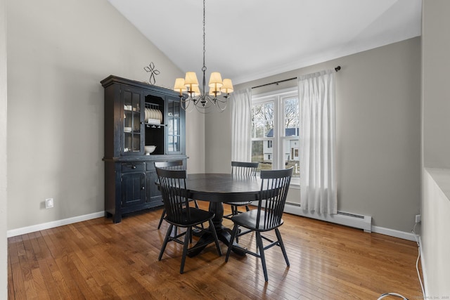 dining room with hardwood / wood-style floors, a notable chandelier, vaulted ceiling, and baseboard heating