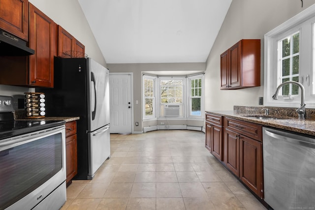 kitchen featuring sink, appliances with stainless steel finishes, dark stone countertops, extractor fan, and vaulted ceiling