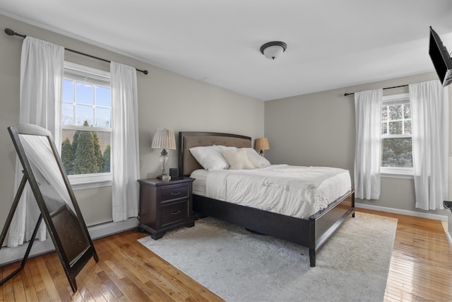 bedroom with wood-type flooring and baseboard heating