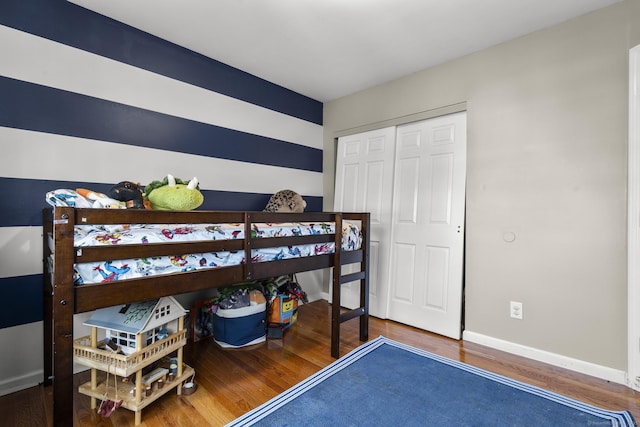 bedroom with dark hardwood / wood-style flooring and a closet