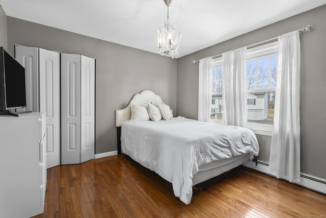 bedroom with dark hardwood / wood-style flooring and an inviting chandelier