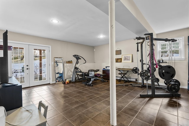 exercise room with dark tile patterned flooring, plenty of natural light, french doors, and a baseboard radiator