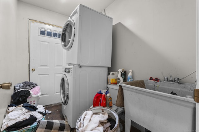 laundry area with stacked washer and dryer and sink