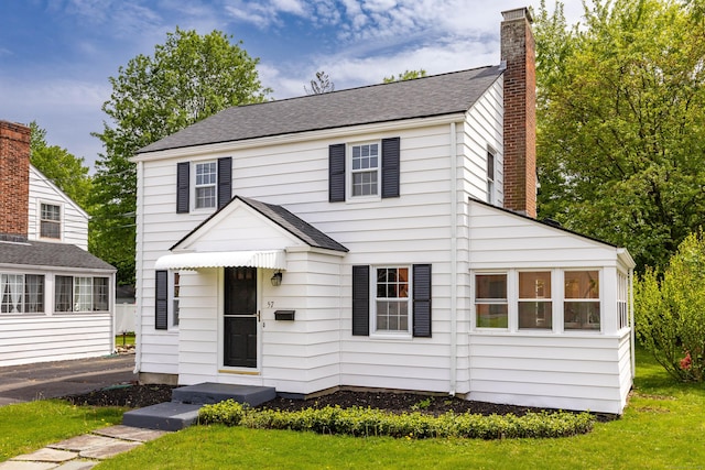 57 Saint James St, West Hartford, CT 06119 - view of front of home with a chimney, a front yard, and roof with shingles