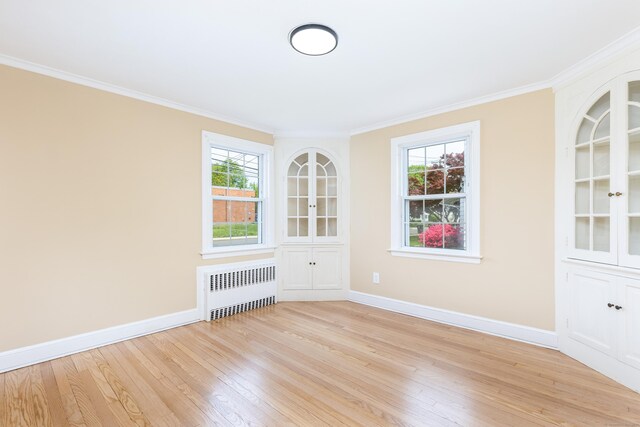 57 Saint James St, West Hartford, CT 06119 - spare room featuring radiator heating unit, light wood-style flooring, ornamental molding, baseboards, and healthy amount of natural light