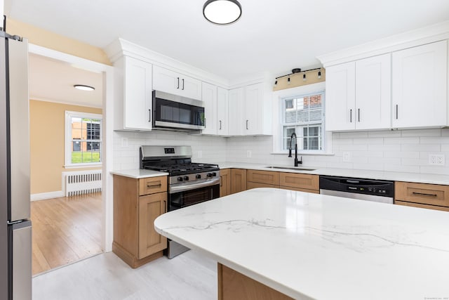 57 Saint James St, West Hartford, CT 06119 - kitchen with appliances with stainless steel finishes, a sink, radiator heating unit, and tasteful backsplash