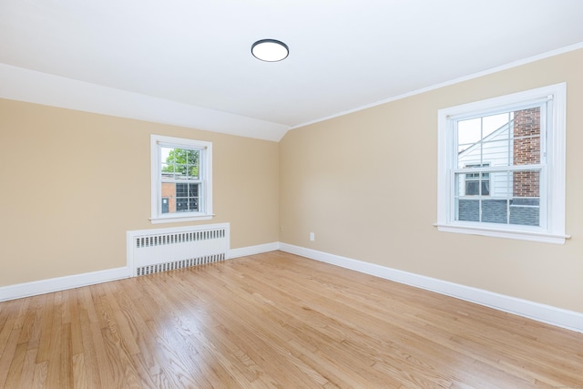 57 Saint James St, West Hartford, CT 06119 - spare room with radiator heating unit, crown molding, baseboards, light wood finished floors, and vaulted ceiling