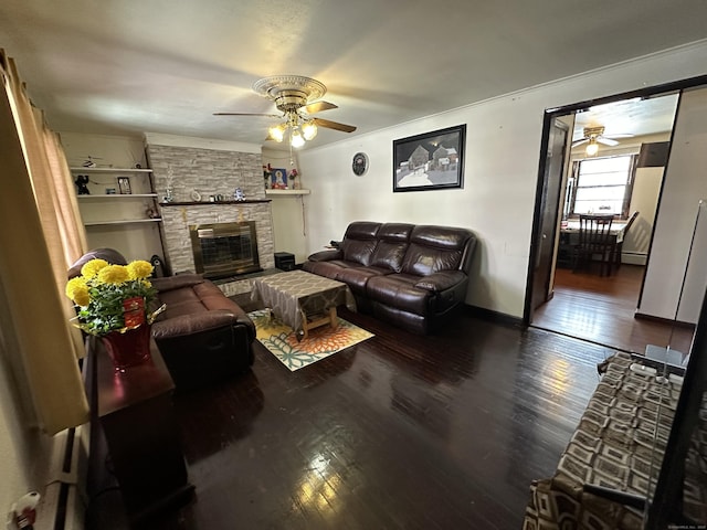 living room with ceiling fan, a fireplace, dark hardwood / wood-style floors, and built in features