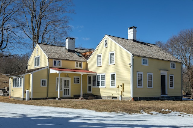 back of property featuring entry steps and a chimney