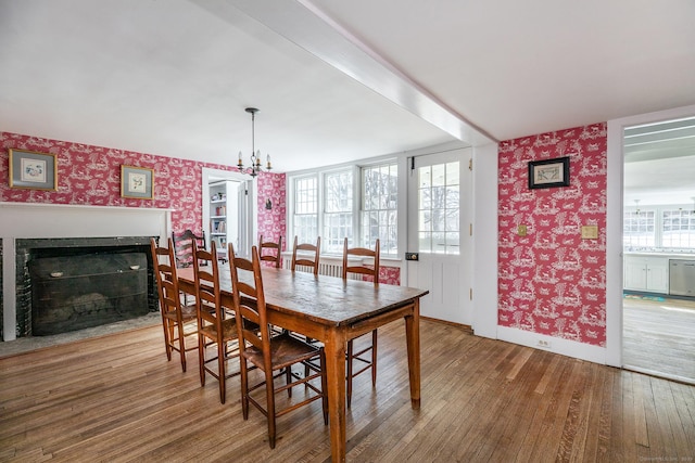 9 Mallory Brook Rd, Washington, CT 06793 - dining area with wallpapered walls, hardwood / wood-style flooring, a chandelier, baseboards, and a fireplace