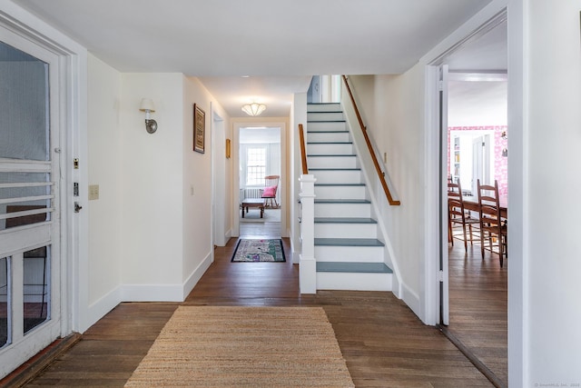 foyer entrance featuring stairs, dark wood finished floors, and baseboards